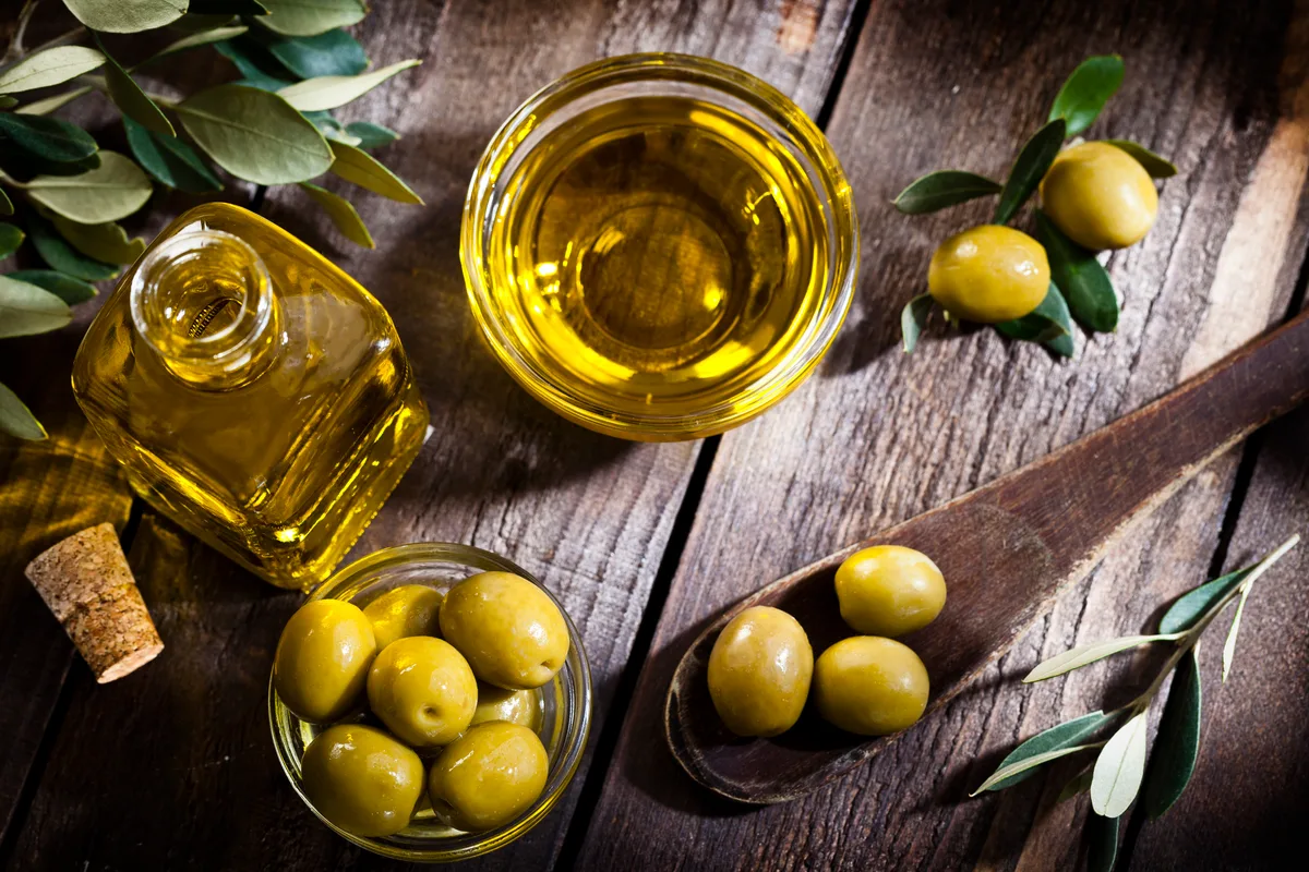 Bottles of olive oil and tins of ghee arranged on a pantry shelf